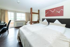 Schlafzimmer mit einem großen weißen Bett und einem Schreibtisch in der Unterkunft S'Matt 3 in Lingenau