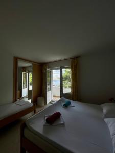 1 dormitorio con 1 cama blanca grande y ventana en Apartments Boras, en Cavtat