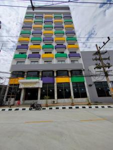 um edifício com janelas coloridas e uma moto em frente em INTERTOWER HOTEL (SHA) em Sungai Kolok
