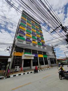 um edifício alto com janelas coloridas numa rua da cidade em INTERTOWER HOTEL (SHA) em Sungai Kolok