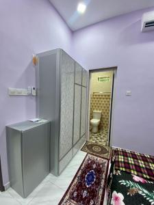 a bathroom with a toilet in a room with a rug at Sheri homestay in Kuala Nerang