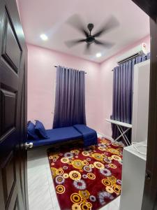 a room with a ceiling fan and a red carpet at Sheri homestay in Kuala Nerang