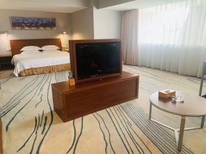 a hotel room with a bed and a flat screen tv at Days Inn Guangzhou in Guangzhou