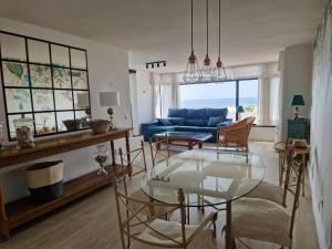 a living room with a blue couch and a glass table at Apartamento primera linea playa in Torremolinos