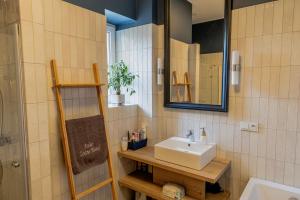 een badkamer met een wastafel en een spiegel bij Atelier Hostel in Leszno