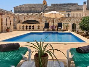 a swimming pool with two chairs and an umbrella at Can Biel in Pina