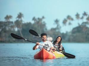 a man and a woman in a kayak on the water at Dream Nest Beach House in Alleppey