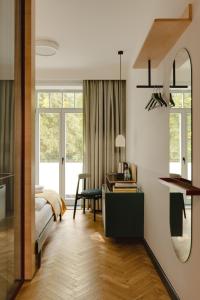 a bedroom with a bed and a desk and a mirror at Willa Wincent in Gdynia