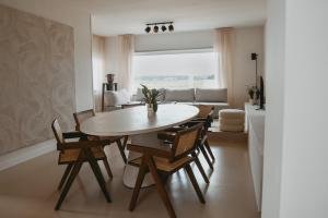 - une salle à manger et un salon avec une table et des chaises dans l'établissement Maas Suites - The River House, Maastricht - Lanaken, à Lanaken
