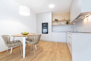 Una cocina y un comedor con mesa y sillas. en Apartmán Al-Garden s private garage parking free, 5 min pešo do centra, en Košice 9 fotos más