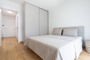 - une chambre blanche avec un grand lit blanc dans l'établissement Apartmán Al-Garden s private parking, 5 min pešo do centra, à Košice