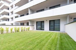 une cour vide d'un bâtiment avec pelouse dans l'établissement Apartmán Al-Garden s private parking, 5 min pešo do centra, à Košice