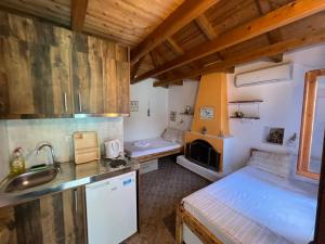 una pequeña cocina con 2 camas y lavamanos en Aliki Stone House, en Alyki