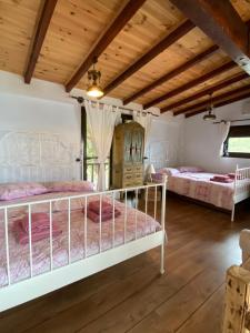 two beds in a room with wooden ceilings at Villa Haris in Sarti