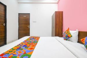 1 dormitorio con 1 cama grande y edredón colorido en FabExpress Golden Epoch en Indore