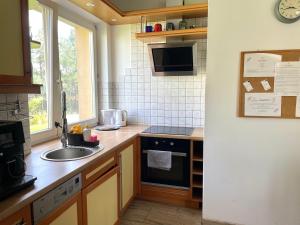 a kitchen with a sink and a stove at Wynajem Pokoi Villa Kofeina in Gdańsk