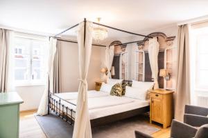sypialnia z łóżkiem z baldachimem i zasłonami w obiekcie Boutiquehotel Amadeus w mieście Salzburg