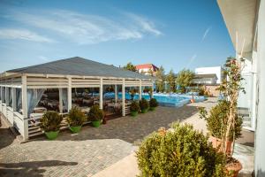 a pavilion with potted plants next to a swimming pool at Villa Santorini in Zatoka