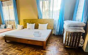 a bedroom with a bed and two windows with blue curtains at Oceanis Park Andakana 