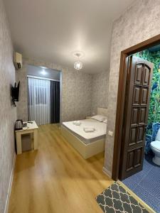een slaapkamer met een bed, een wastafel en een toilet bij Hotel Old Boulvared in Batoemi