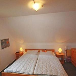 a bedroom with a large bed with two night stands at Morgenroete in Lemkenhafen auf Fehmarn