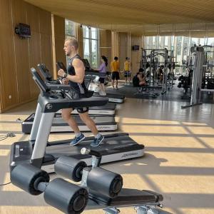 un homme qui court sur un tapis de course dans une salle de sport dans l'établissement Studio, West Jakarta Oasis, Netflix, Pool, Mall, à Jakarta