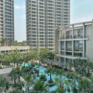 - une vue aérienne sur un complexe avec des palmiers et un bâtiment dans l'établissement Studio, West Jakarta Oasis, Netflix, Pool, Mall, à Jakarta