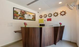 a reception desk in a room with clocks on the wall at Treebo Trend vSaffron Regency - Punnamada Lake in Alleppey