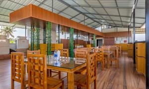 una sala da pranzo con tavolo e sedie in legno di Treebo Trend vSaffron Regency - Punnamada Lake a Alleppey