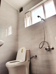 a bathroom with a toilet and a window at Mitra Hostel Sonamarg in Sonāmarg