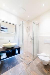 uma casa de banho com uma cabina de duche em vidro e um WC. em S'Matt Bob em Feldkirch