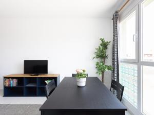 a dining room with a black table and a tv at Live Medano Mirazul in El Médano