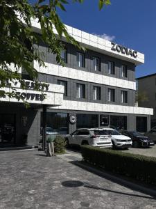 a koko building with cars parked in front of it at Zodiac in Atyraū