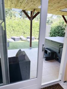 een glazen schuifdeur naar een patio met een grill bij WellnessStudioTiel in Tiel