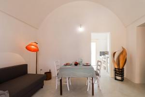 een eetkamer met een tafel en stoelen en een bank bij Terra di Sud 2 by Casa di Marco in Sannicola