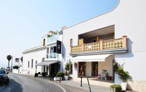 a white building with a balcony on a street at Centralissimo Monolocale con Terrazzino Vista Mare in Leuca