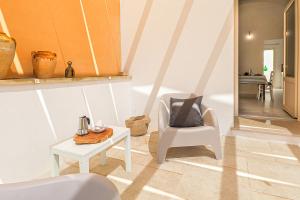 een woonkamer met een stoel en een tafel bij Terra di Sud 2 by Casa di Marco in Sannicola