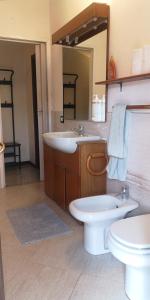 bagno con lavandino, servizi igienici e specchio di Casa Romeo a Manerbio
