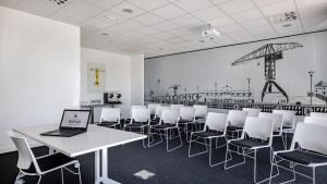 a room with a laptop on a table and chairs at Akena Nantes Atlantis Zénith in Saint-Herblain