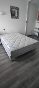 a bed in a room with a white mattress at Studio Cap d'Agde la grande voile in Cap d'Agde +23 photos