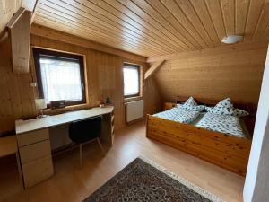 - une chambre avec un lit et un bureau dans l'établissement Haus Tannenzäpfle, à Waldachtal