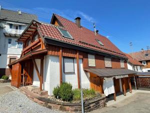 une maison en bois avec un toit rouge dans une rue dans l'établissement Haus Tannenzäpfle, à Waldachtal