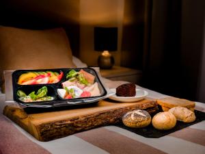 a tray of food on a table with bread and fruit at Aparthotel Grodzka 21 in Krakow