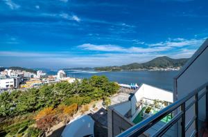 a view of the ocean from a balcony of a house at Tongyeong V Motel in Tongyeong