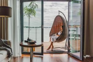 a woman sitting in a hammock on a balcony at Hotel Mikołajki Leisure & SPA - Destigo Hotels in Mikołajki