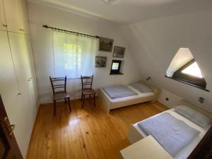 a bedroom with two beds and two chairs and a window at Country House Pri Lipet Žiri in Žiri