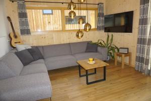 a living room with a gray couch and a table at Alpenchalét Alpakablick in Sankt Lorenzen ob Murau