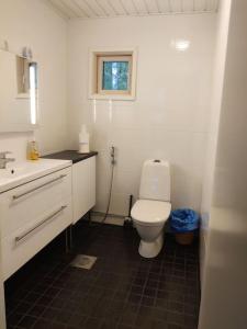 a white bathroom with a toilet and a sink at Cottage by the sea in Turku