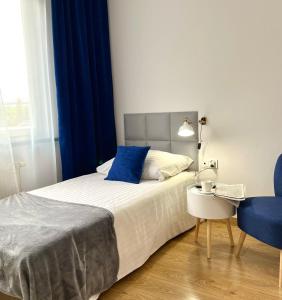 1 dormitorio con 1 cama y 1 silla azul en Hotel 500 W Strykowie, en Stryków