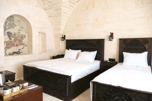 two beds in a room with a room with at Abraham Otel in Sanlıurfa
